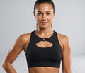 Woman wearing a black sports bra against a gray background